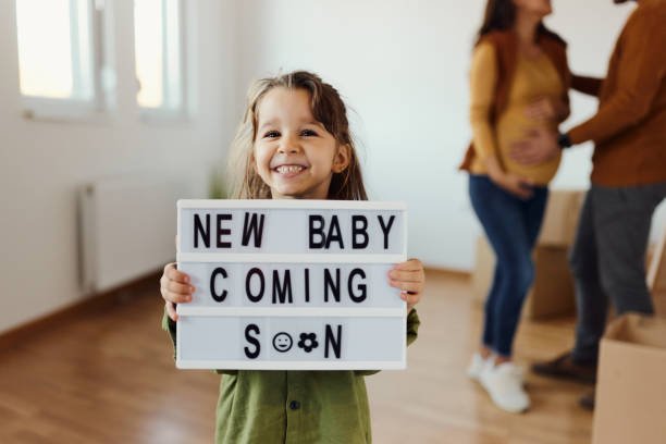 A little girl holding a pregnancy announcement 