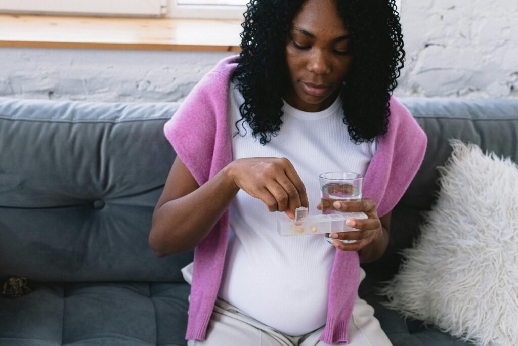 A woman taking prenatal vitamins in the first trimester