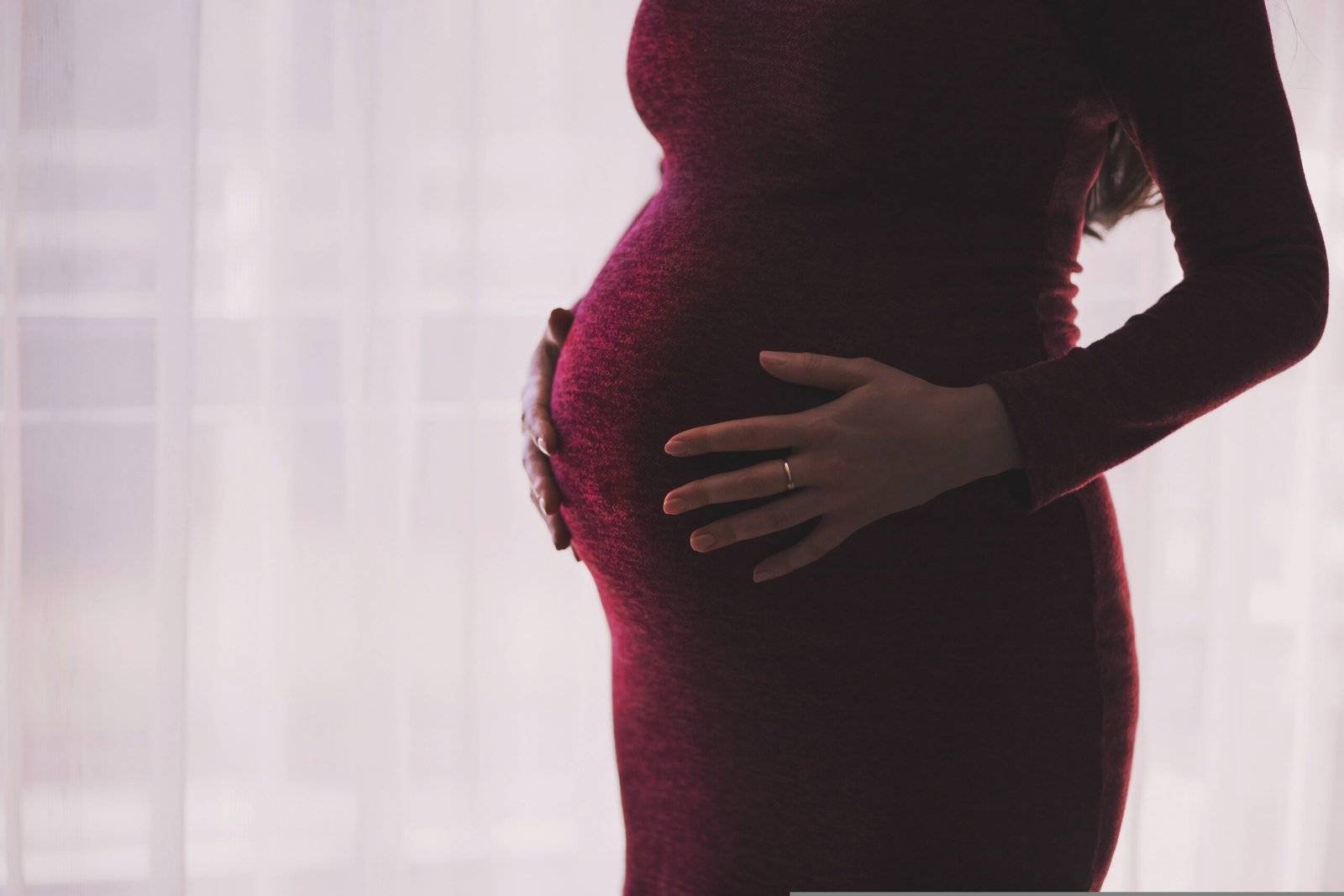 A pregnant woman touching her pregnant belly